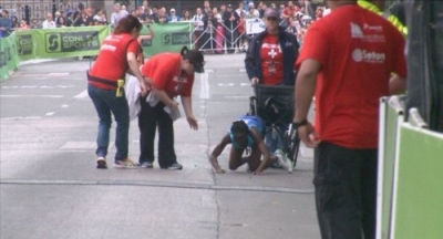 Maratonista cruza a linha de chegada engatinhando